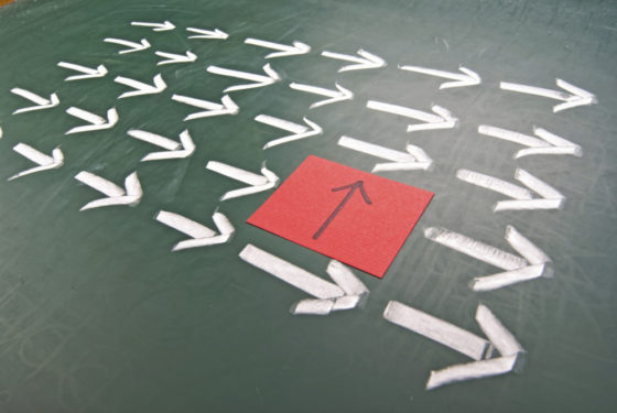 Pfeile zeigen in einer Richtung. Ein roter Pfeil zeigt nach oben.