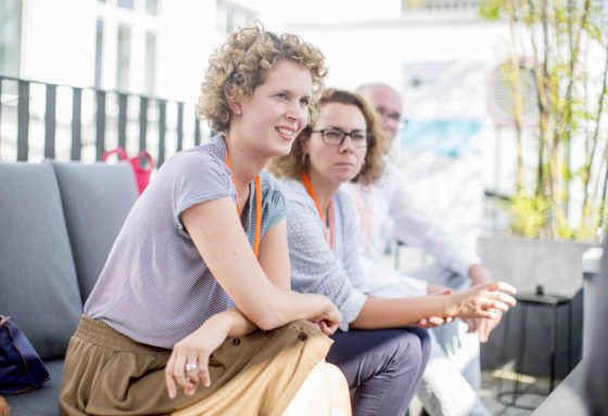 Zwei Frauen sitzen auf einer Terasse und erzählen.