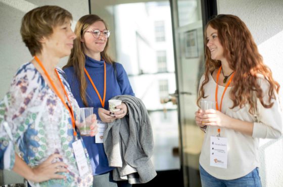 Drei Frauen stehen zusammen und unterhalten sich.