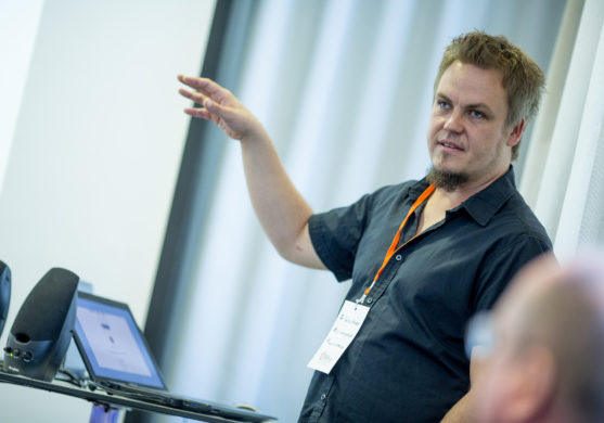 Ein junger Mann erklärt etwas anhand einer Präsentation.