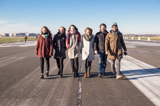 Eine Gruppe von sechs Leuten läuft auf der Start- und Landebahn des ehemaligen Flughafen Tempelhof in Berlin entlang.