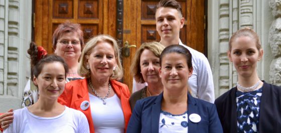 7 Personen stehen als Gruppe vor einem Gebäude mit alter Holztür.