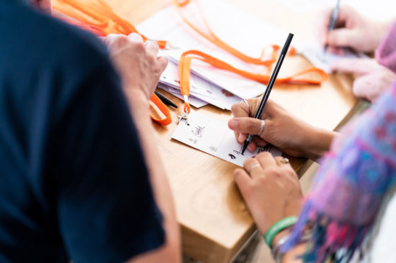 Zwei Hände beschriften eine Karte.