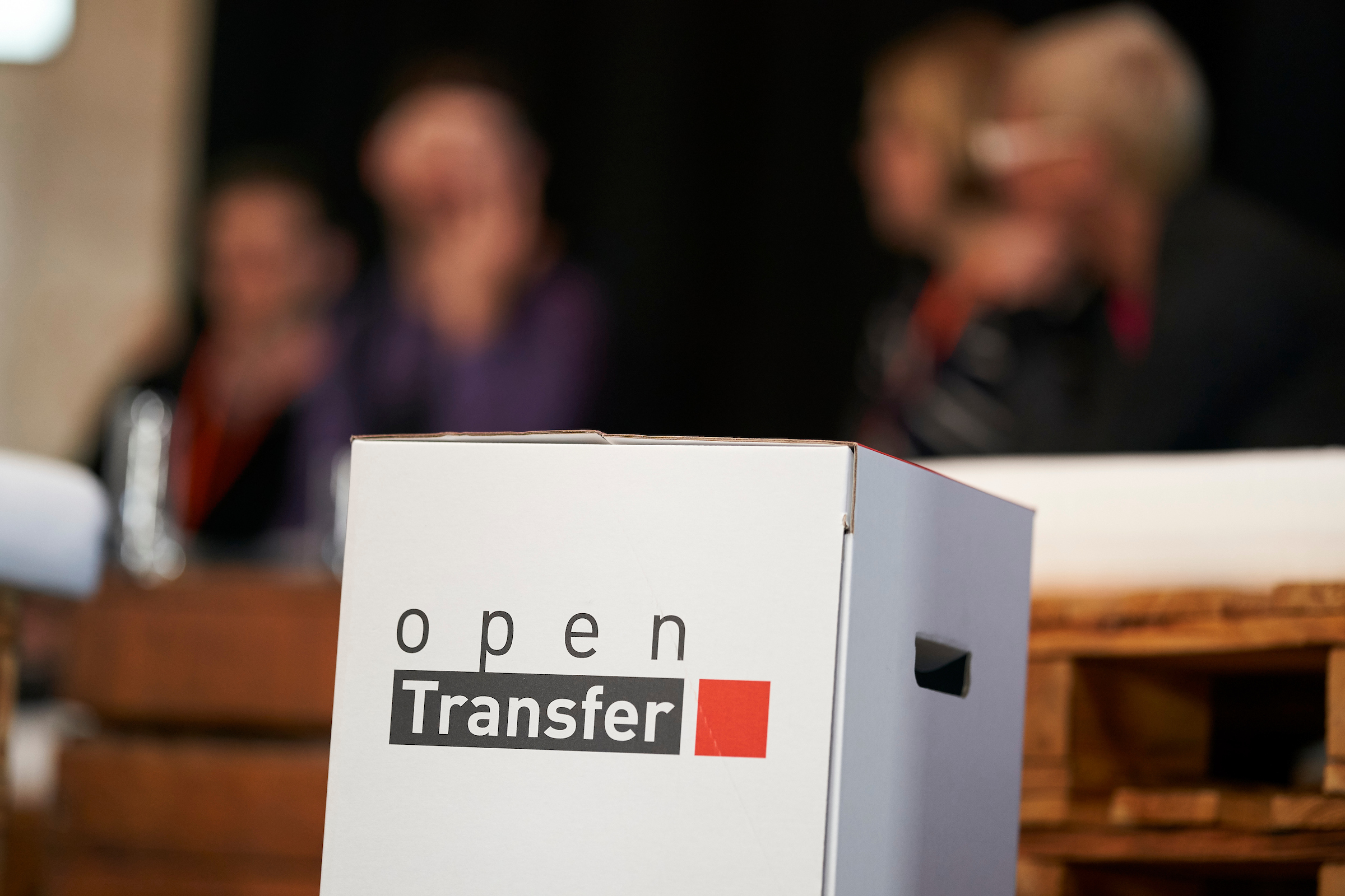 Ein Papphocker mit dem Logo von openTransfer drauf