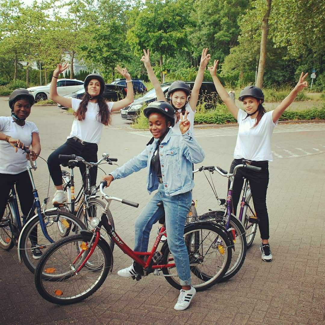 Fünf Mädchen freuen sich auf Fahrrädern zu sitzen