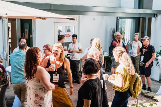 Menschen stehen in einem Hof und unterhalten sich anregend.