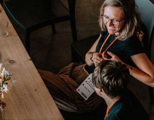 4 Personen unterhalten sich sitzend an einem Tisch