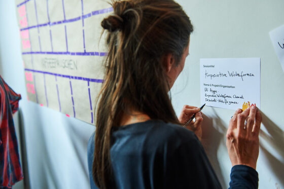 Frau schreibt Infos zu ihrer Session auf eine Karte.