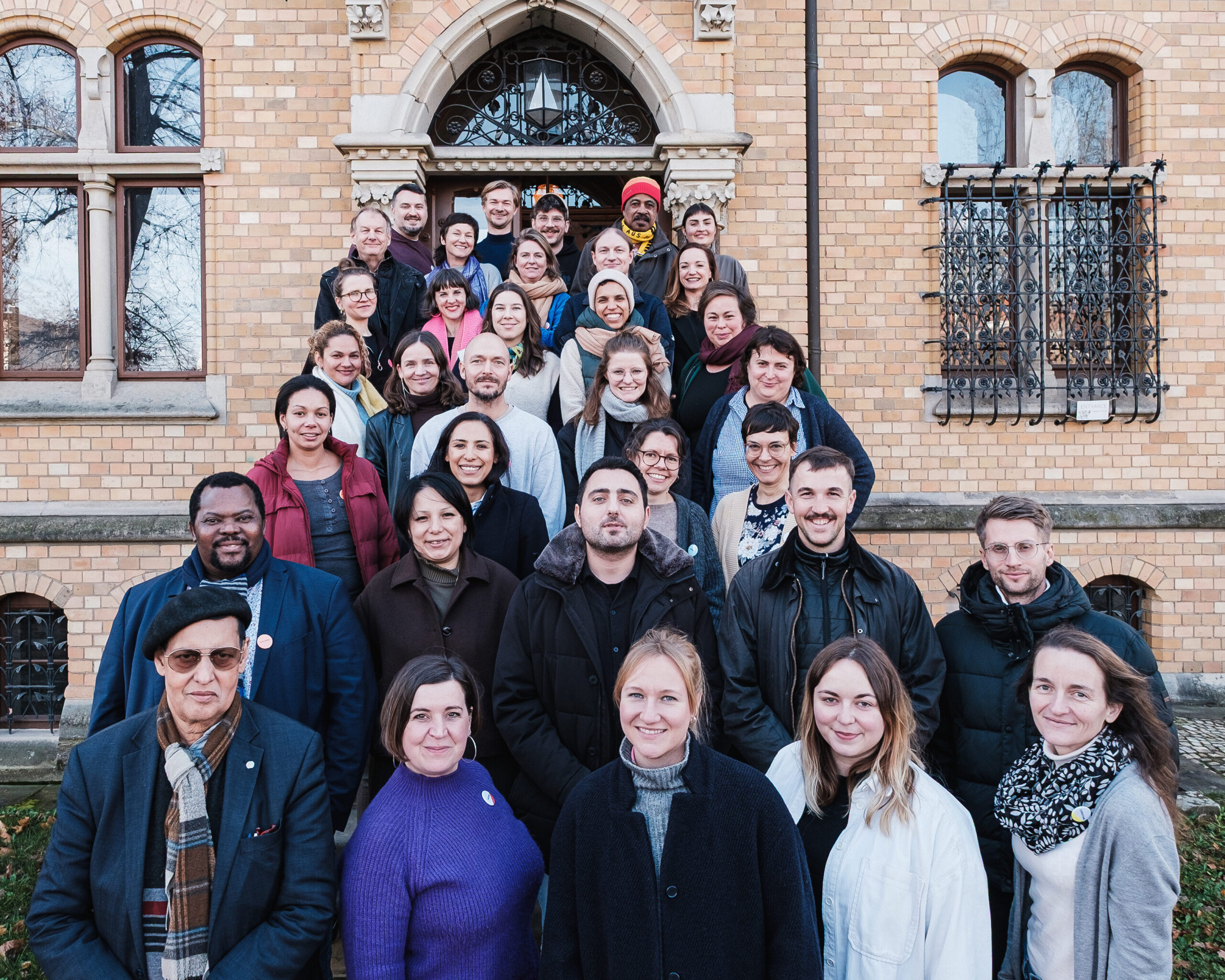 Gruppenbild mit ca. 25 Personen vor dem Eingang eines Gebäudes stehen.