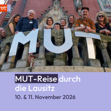 Teilnehmende einer früheren MUT-Reise stehen gemeinsam hinter großen Buchstaben mit dem Schriftzug ‚MUT‘